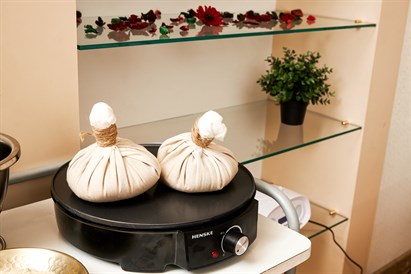 Masažas su šiltais žolelių ryšulėliais